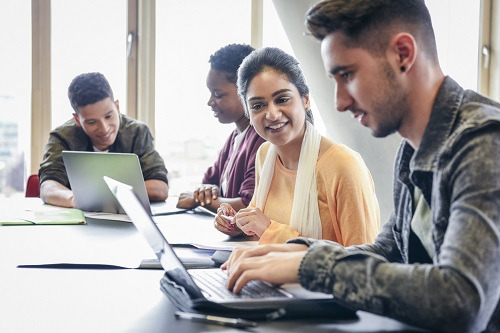 image of students working and learning together on laptops