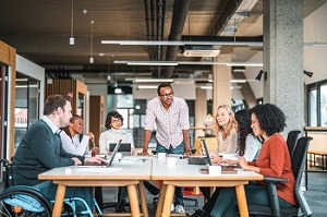 image of team working together at a table in an open office 